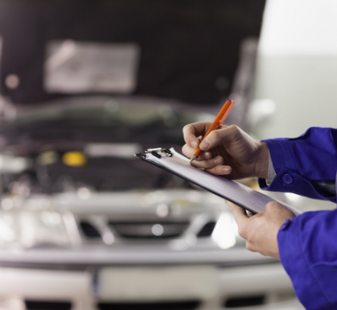 man writing on a clipboard in a garage
